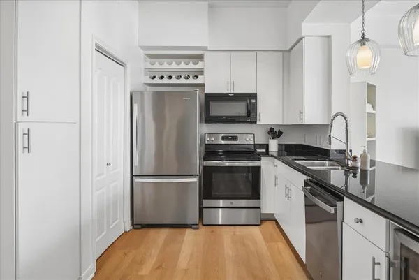 a kitchen with a refrigerator stainless steel appliances a sink and cabinets