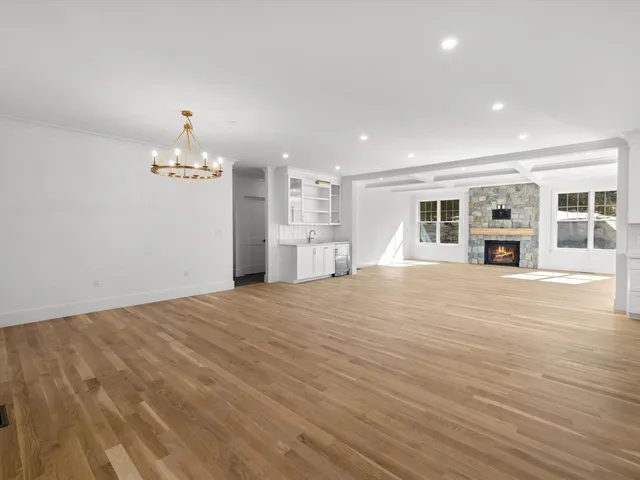 a kitchen with stainless steel appliances granite countertop a sink a stove and white cabinets with wooden floor