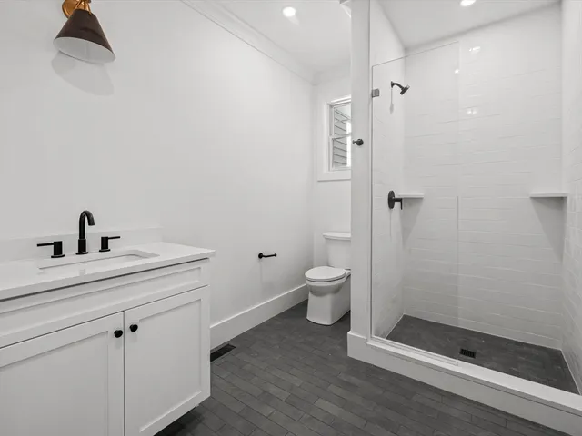 a bathroom with a sink a toilet and shower