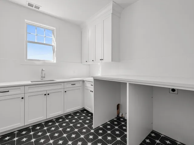 a room with granite countertop white cabinets and sink