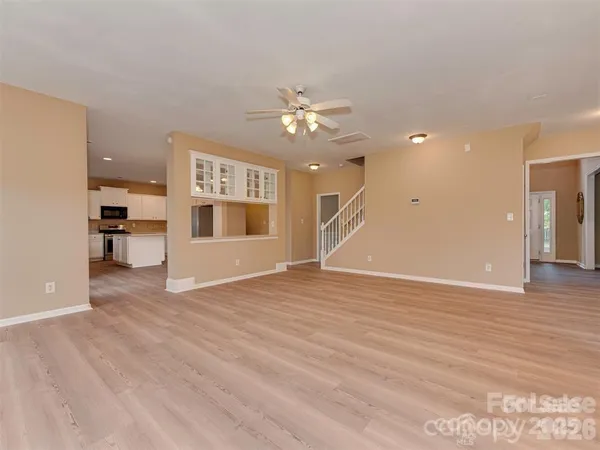 a view of a kitchen with a stove cabinets wooden floor and a ceiling fan