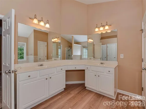 a spacious bathroom with a granite countertop sink a large mirror and a vanity