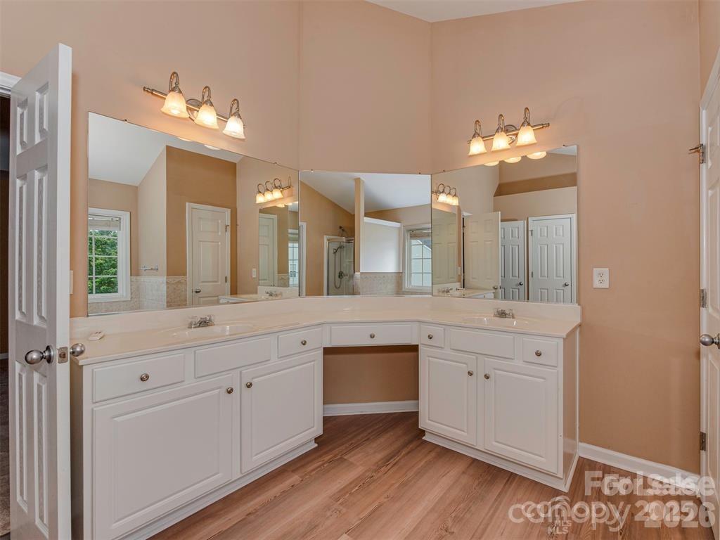 5607 Fulton Ridge Drive Indian Trail, NC 28079 - Photo 35 of 44 a spacious bathroom with a granite countertop sink a large mirror and a vanity