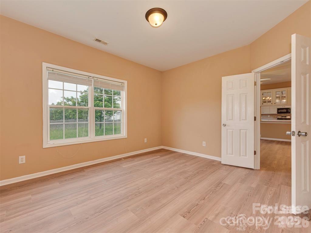 5607 Fulton Ridge Drive Indian Trail, NC 28079 - Photo 9 of 44 an empty room with wooden floor and windows