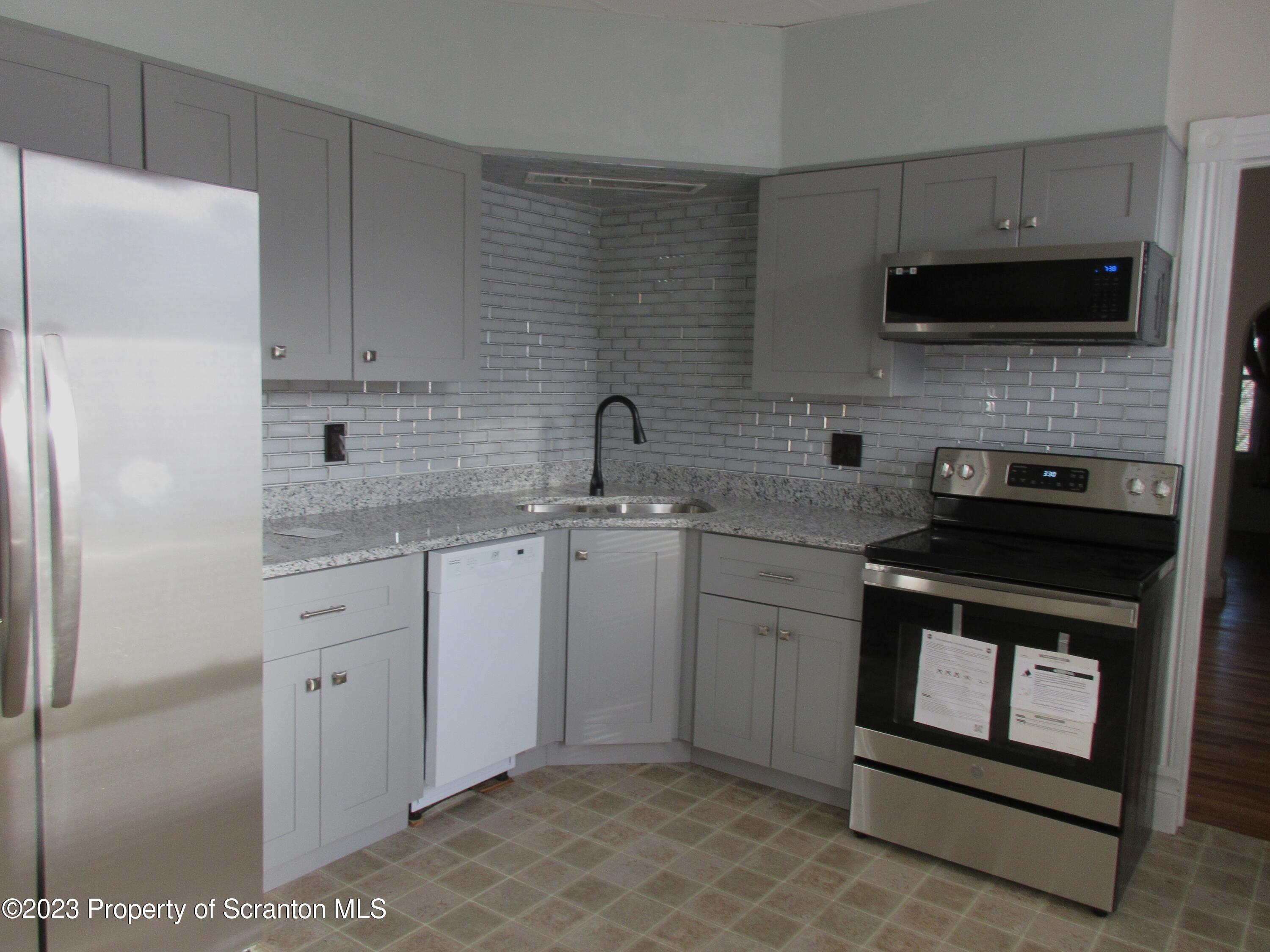 705 North Main Avenue Scranton, PA 18504 - Photo 9 of 25 a kitchen with a sink stove and microwave