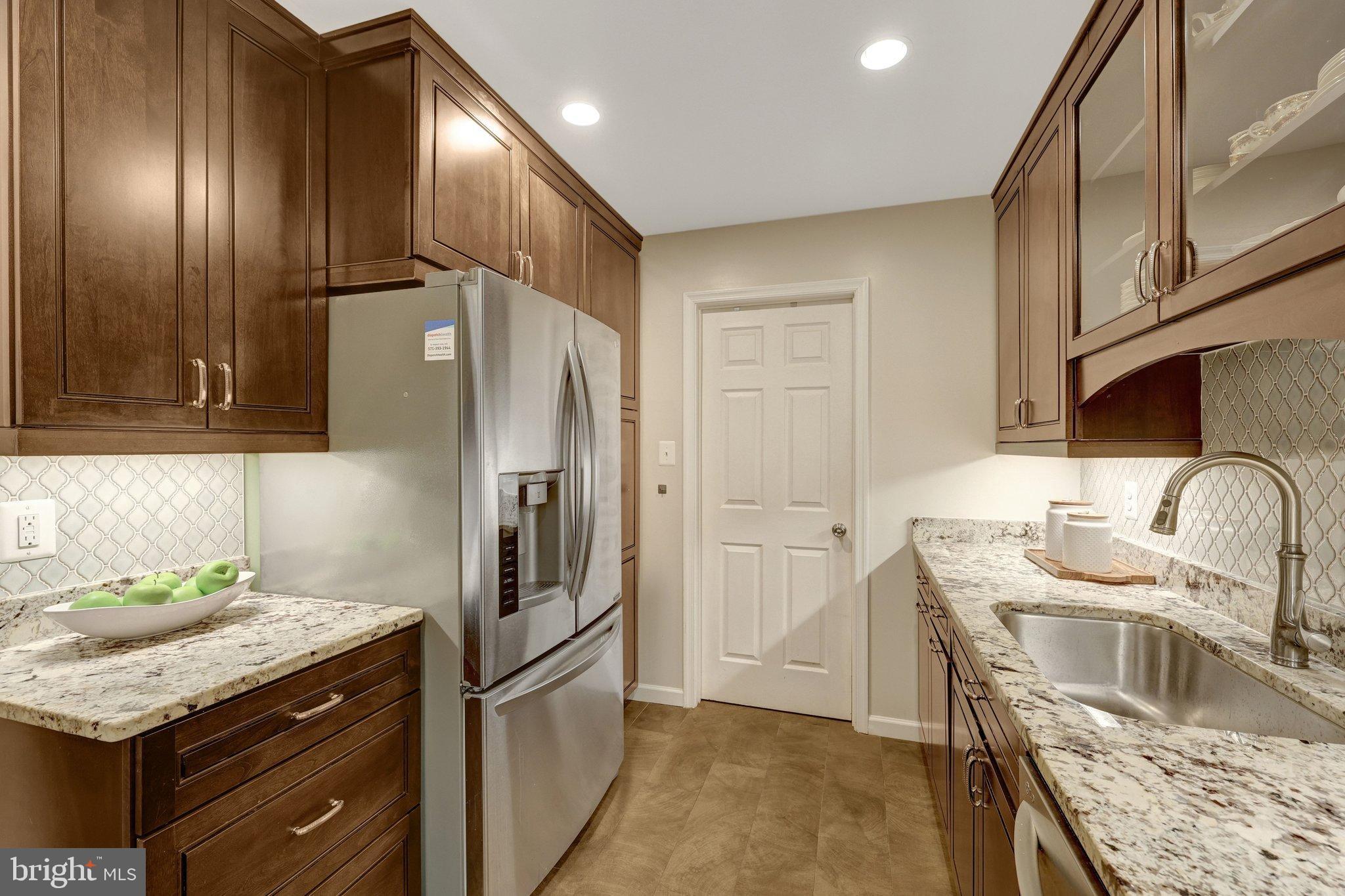 1008 Moore Place Southwest Vienna, VA 22180 - Photo 19 of 55 a kitchen with stainless steel appliances granite countertop a refrigerator and a sink