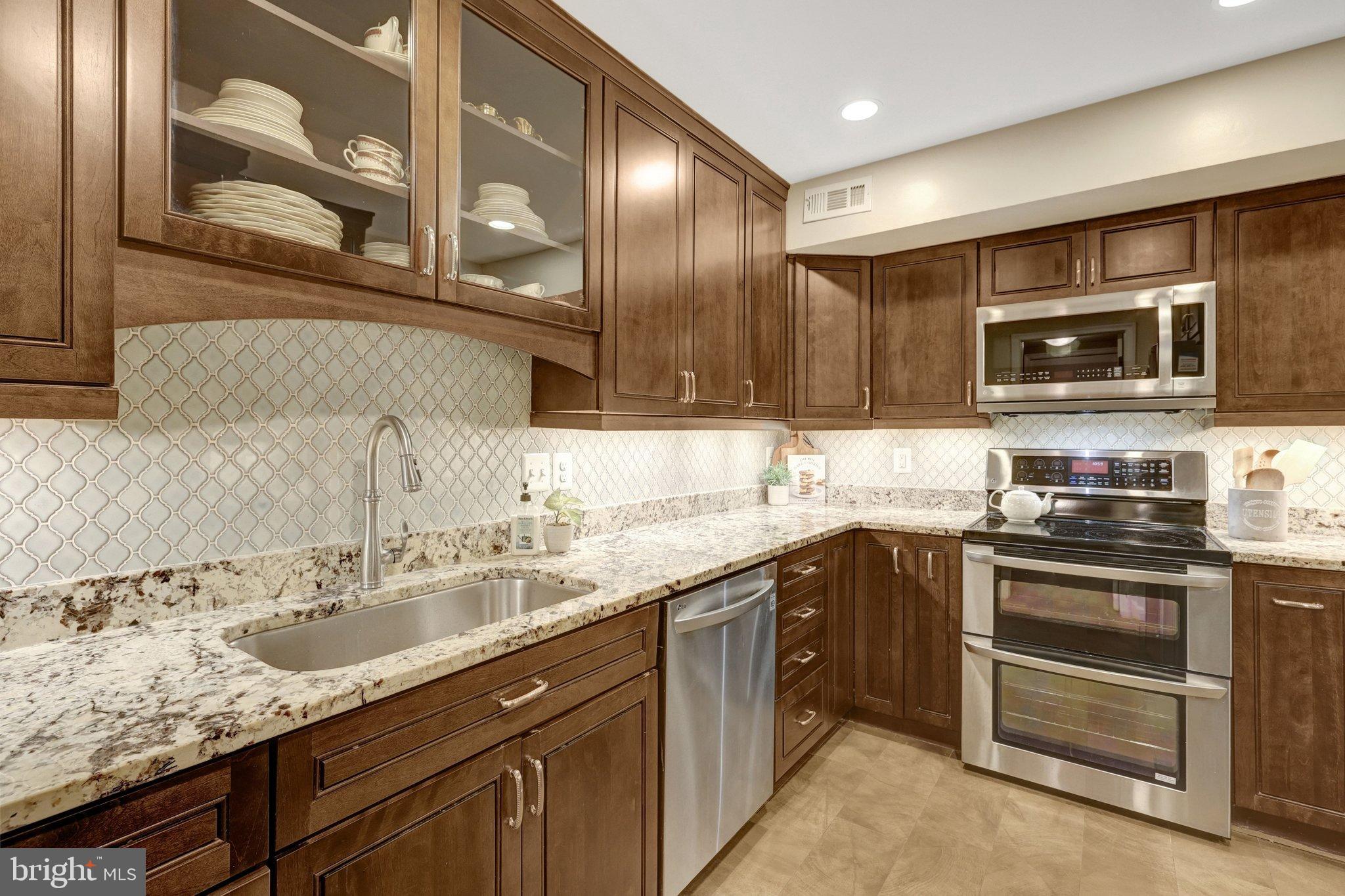 1008 Moore Place Southwest Vienna, VA 22180 - Photo 22 of 55 a kitchen with stainless steel appliances granite countertop a sink and stove top oven
