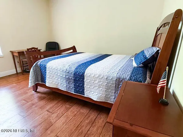 a bedroom with bed and wooden floor