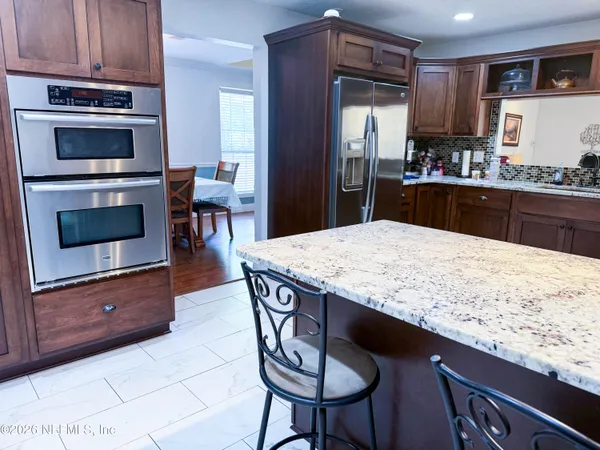 a kitchen with granite countertop kitchen island wooden cabinets and stainless steel appliances
