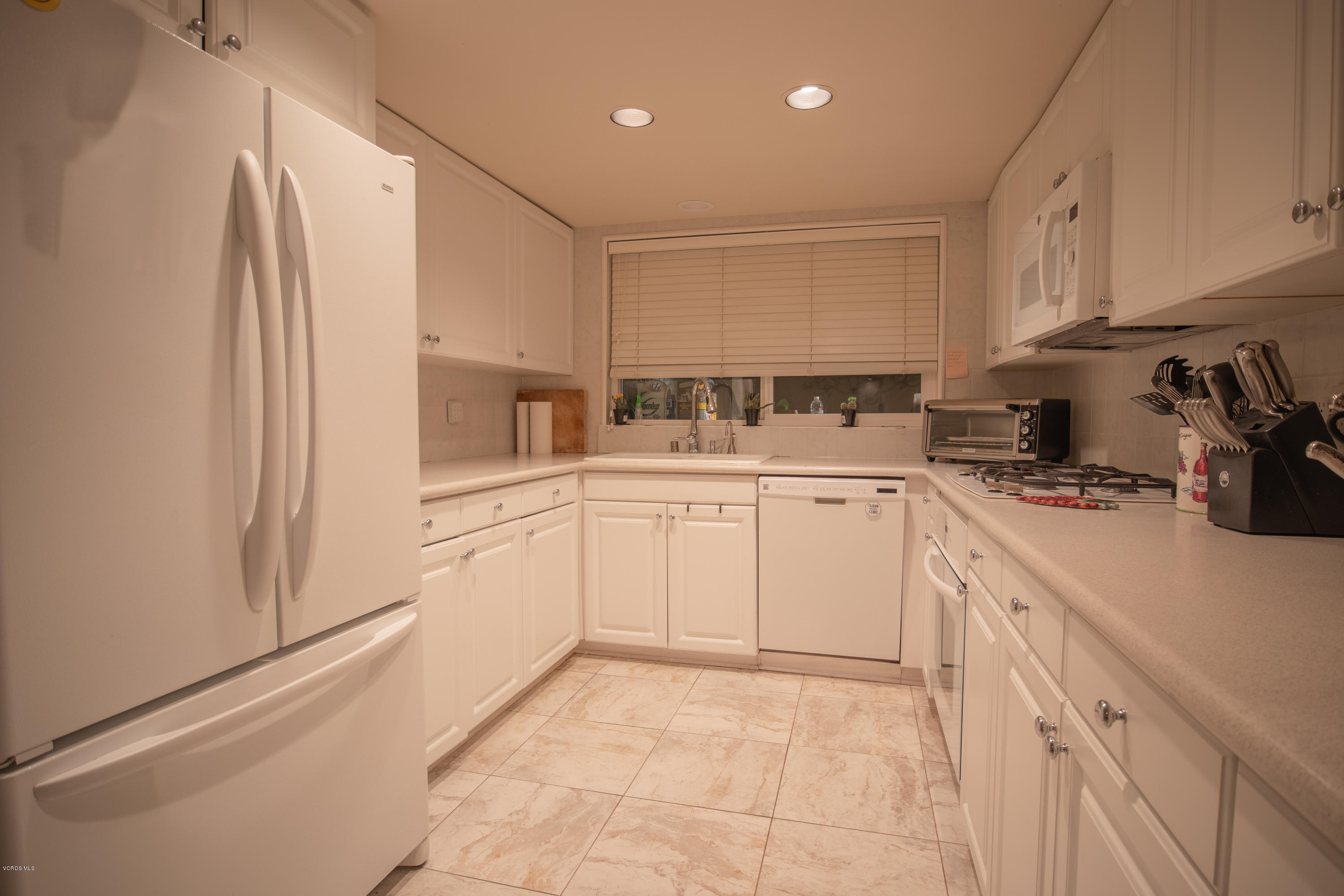 1113 Waltham Road Simi Valley, CA 93065 - Photo 5 of 20 a kitchen with white cabinets and white appliances