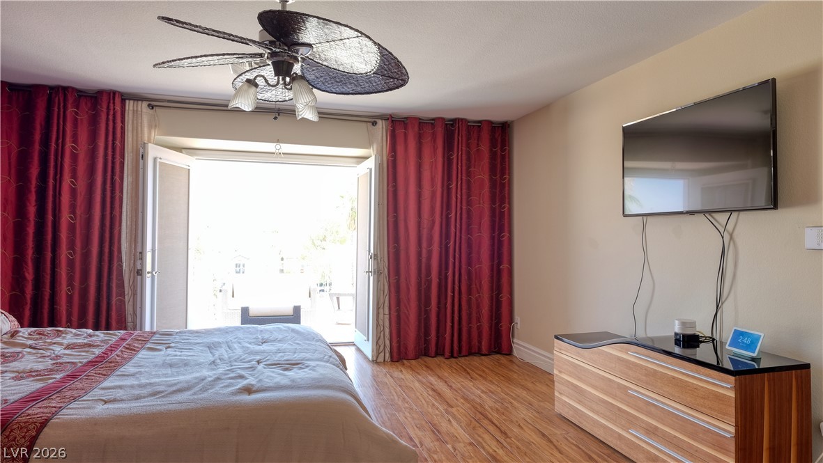 3704 North Campbell Road Las Vegas, NV 89129 - Photo 36 of 46 Warm wood-look flooring and an inviting outdoor access enhance this primary bedroom.