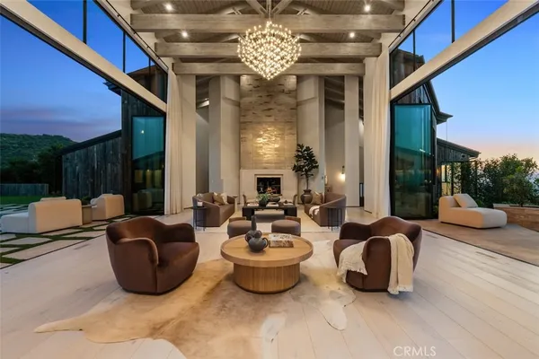a living room with patio furniture and a chandelier