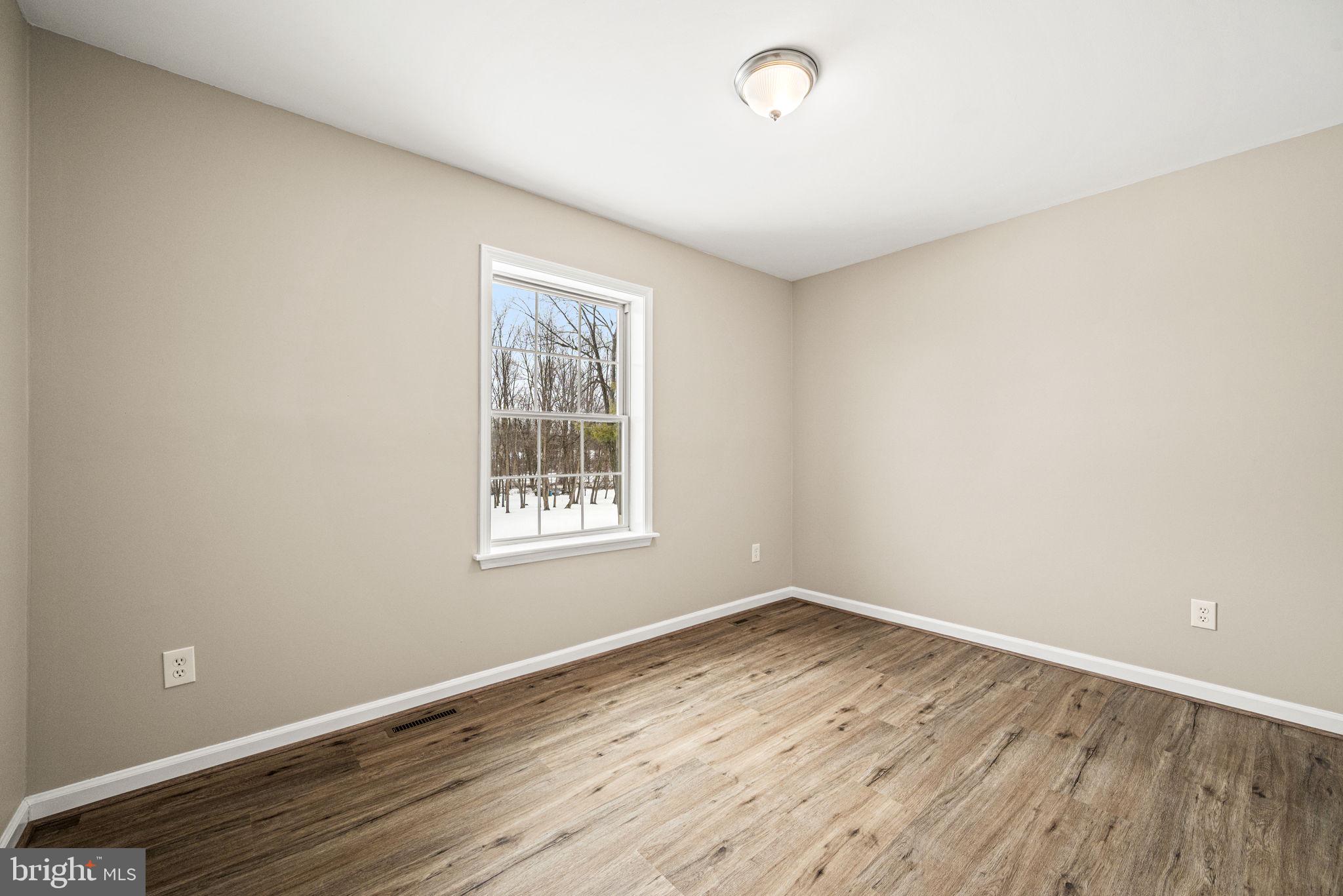 3096 Upper Valley Road Parkesburg, PA 19365 - Photo 12 of 31 an empty room with wooden floor and windows