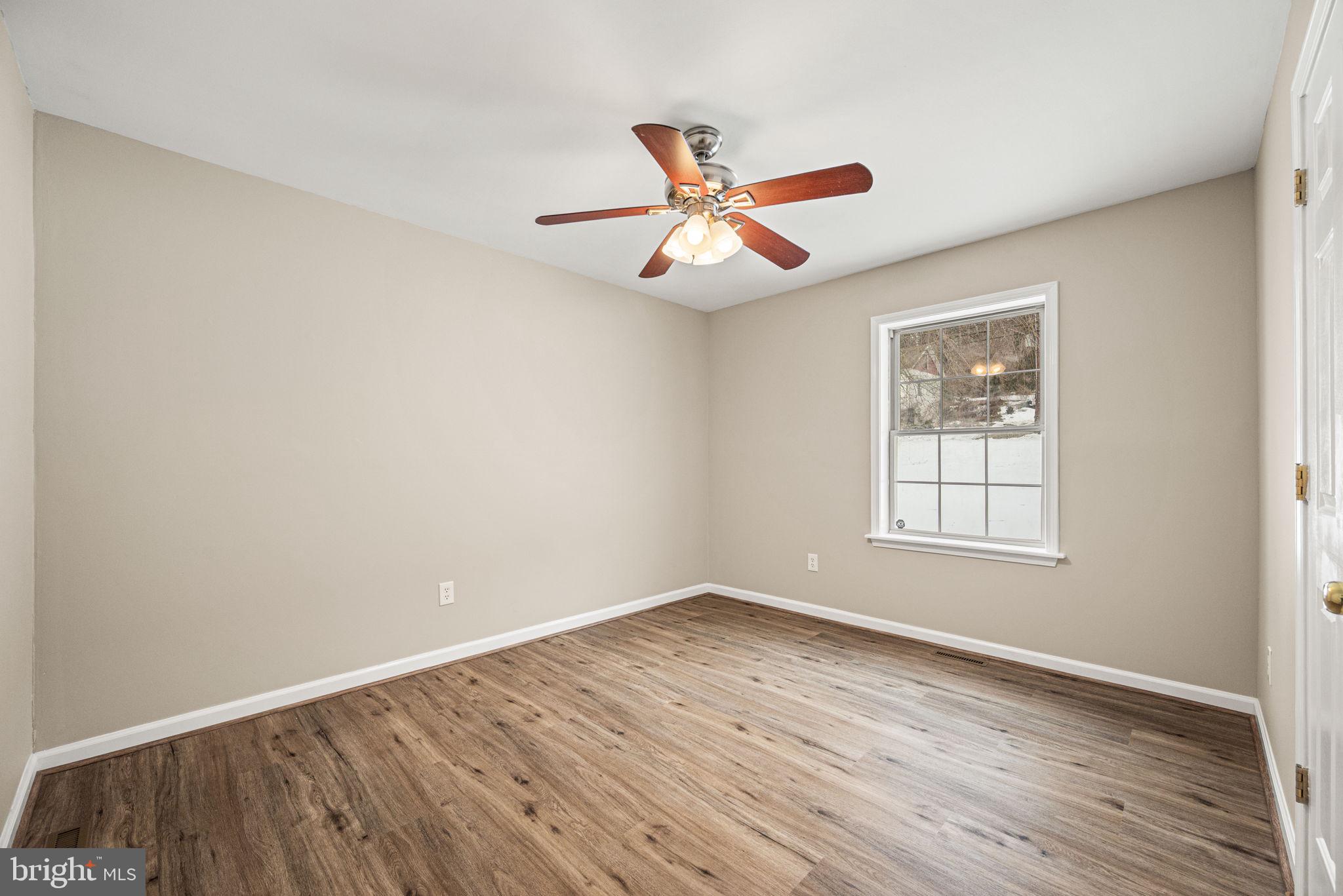 3096 Upper Valley Road Parkesburg, PA 19365 - Photo 13 of 31 an empty room with wooden floor ceiling fan and windows