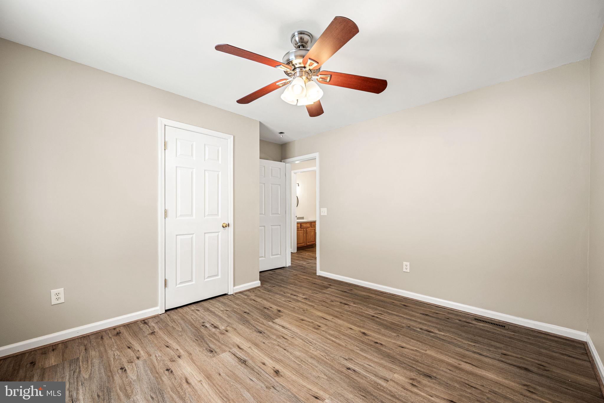 3096 Upper Valley Road Parkesburg, PA 19365 - Photo 19 of 31 a view of an empty room with wooden floor and a ceiling fan
