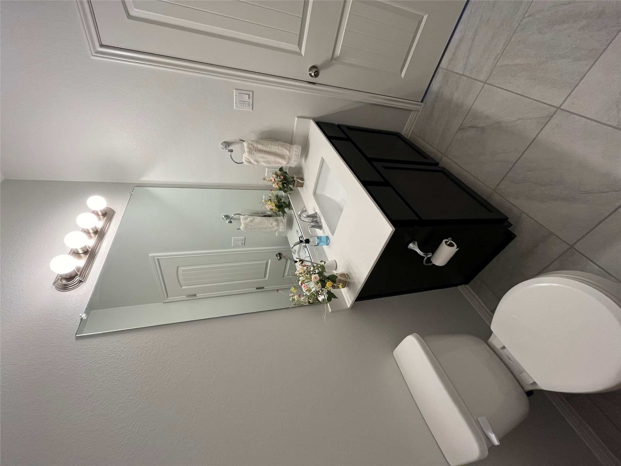 8145 Daisy Cutter Crossing Georgetown, TX 78626 - Photo 19 of 25 Modern bathroom featuring a dark wood-finish vanity with a light-toned countertop, an undermount sink, and a large wall-mounted mirror