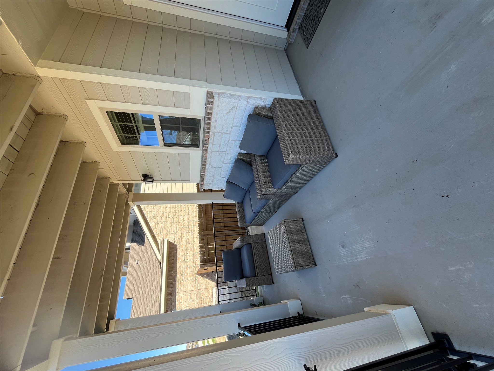 8145 Daisy Cutter Crossing Georgetown, TX 78626 - Photo 4 of 25 Covered outdoor patio with a painted concrete floor, white siding, and a stone accent wall