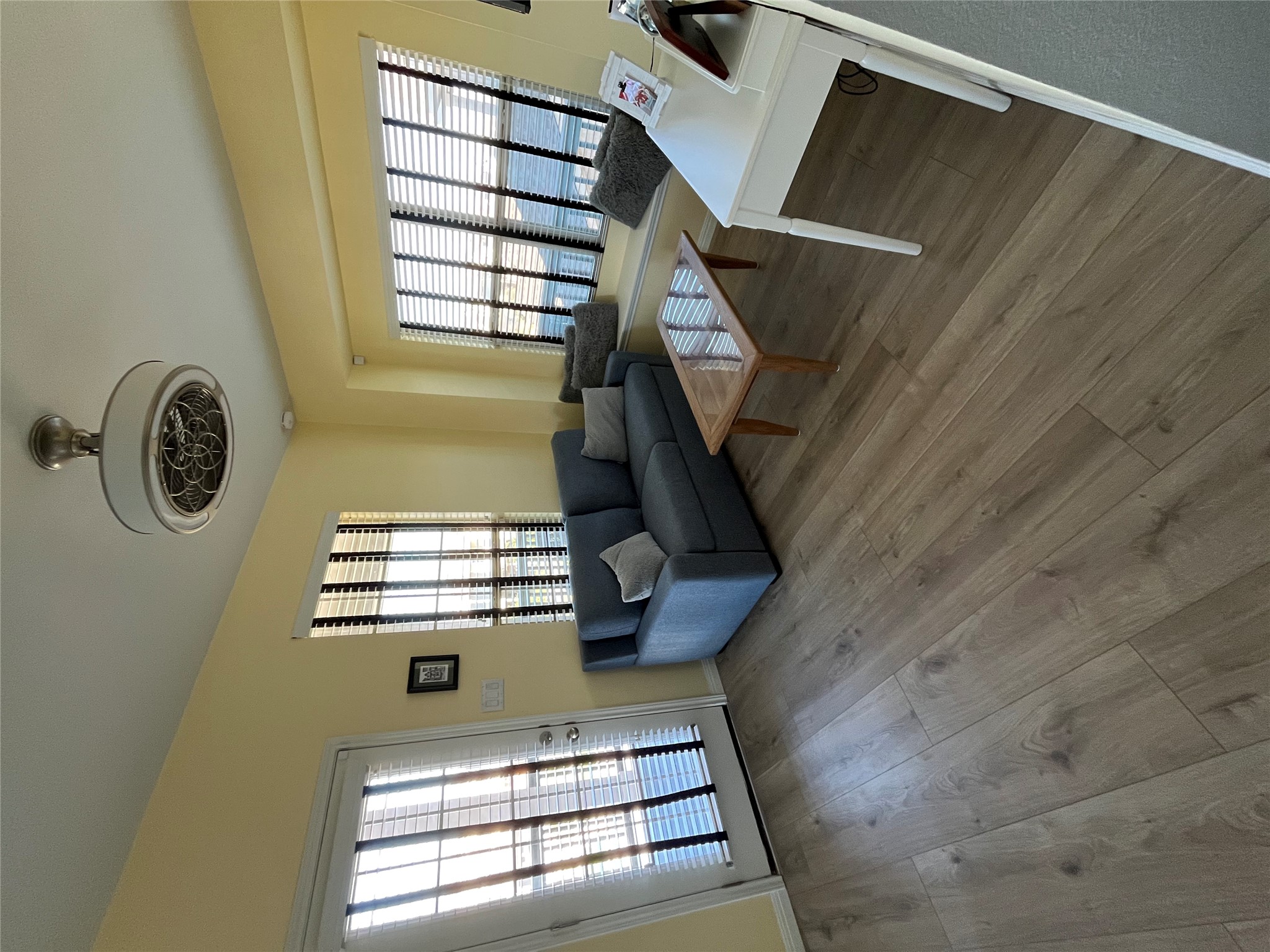 8145 Daisy Cutter Crossing Georgetown, TX 78626 - Photo 9 of 25 Spacious room featuring wood-finish flooring, a ceiling-mounted light fixture with fan, multiple windows with horizontal blinds, a built-in window bench, and a glass-paneled door