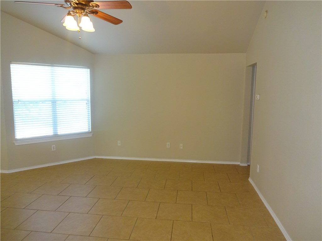 Undisclosed Address Corpus Christi, TX 78414 - Photo 2 of 16 an empty room with a chandelier fan and windows