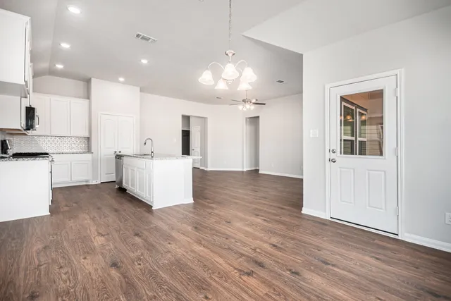a large room with kitchen view and a refrigerator