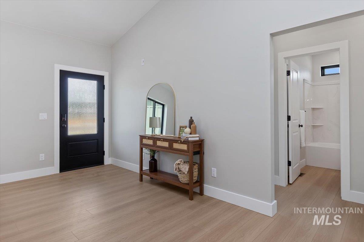 1201 Jade Drive Rupert, ID 83350 - Photo 3 of 27 Spacious entry area featuring wood-finish flooring, a contemporary black door with a frosted glass insert, and high ceilings