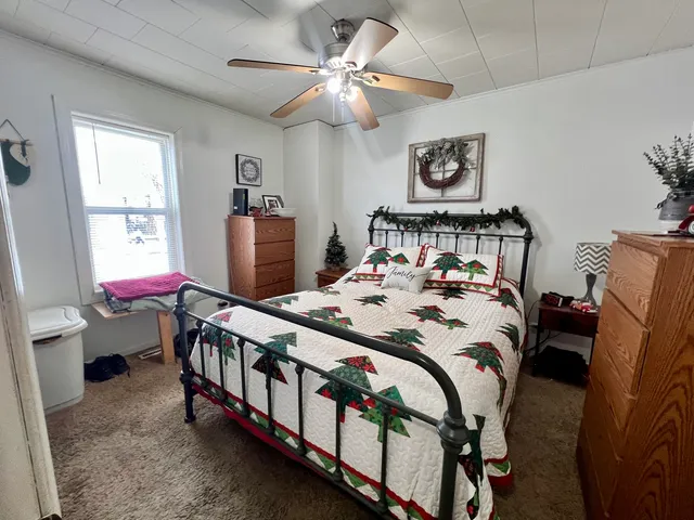 a bedroom with a bed a chandelier and dresser