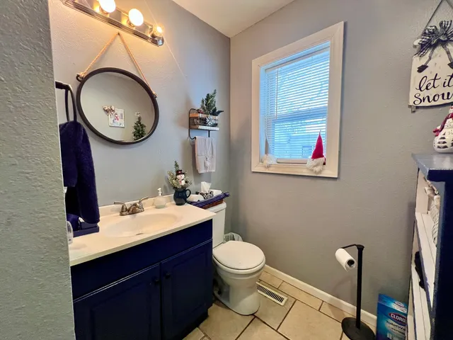 a bathroom with a toilet sink vanity and mirror