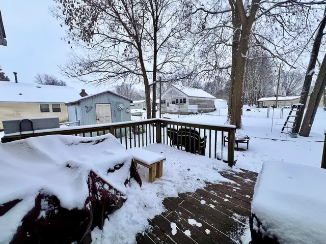 a view of a roof deck with wooden fence and a couple of chairs