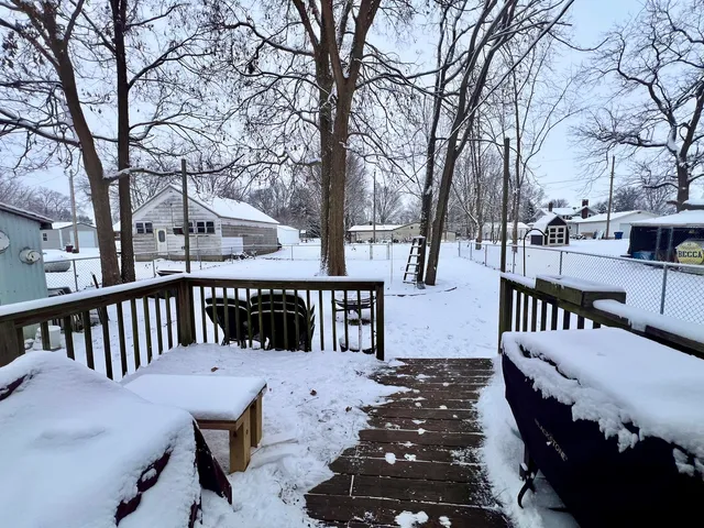 a view of a chairs and deck in the backyard