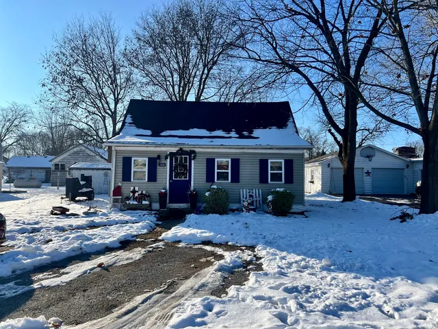 a front view of a house with garden covered with snow