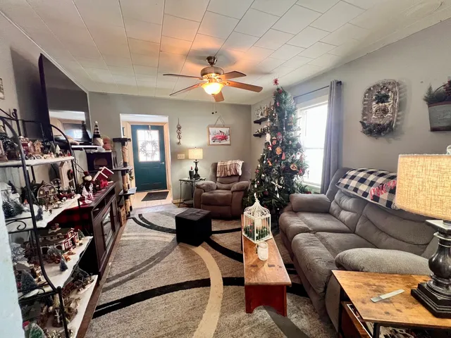 a living room with furniture a chandelier and a flat screen tv