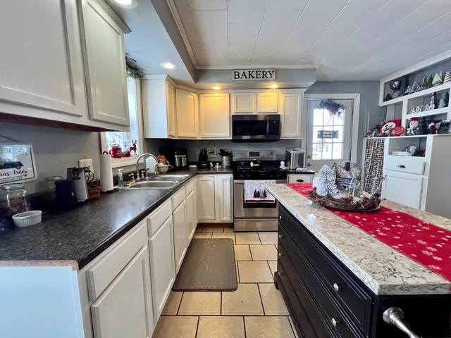 a kitchen with stainless steel appliances granite countertop a sink counter space cabinets and a window