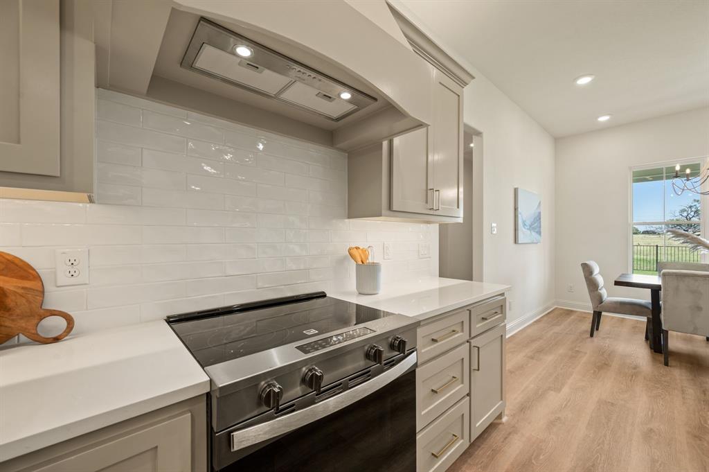 2705 Gospel Road Tolar, TX 76476 - Photo 13 of 36 Kitchen featuring light gray cabinetry, white subway tile backsplash, stainless steel range, and light-toned luxury vinyl flooring
