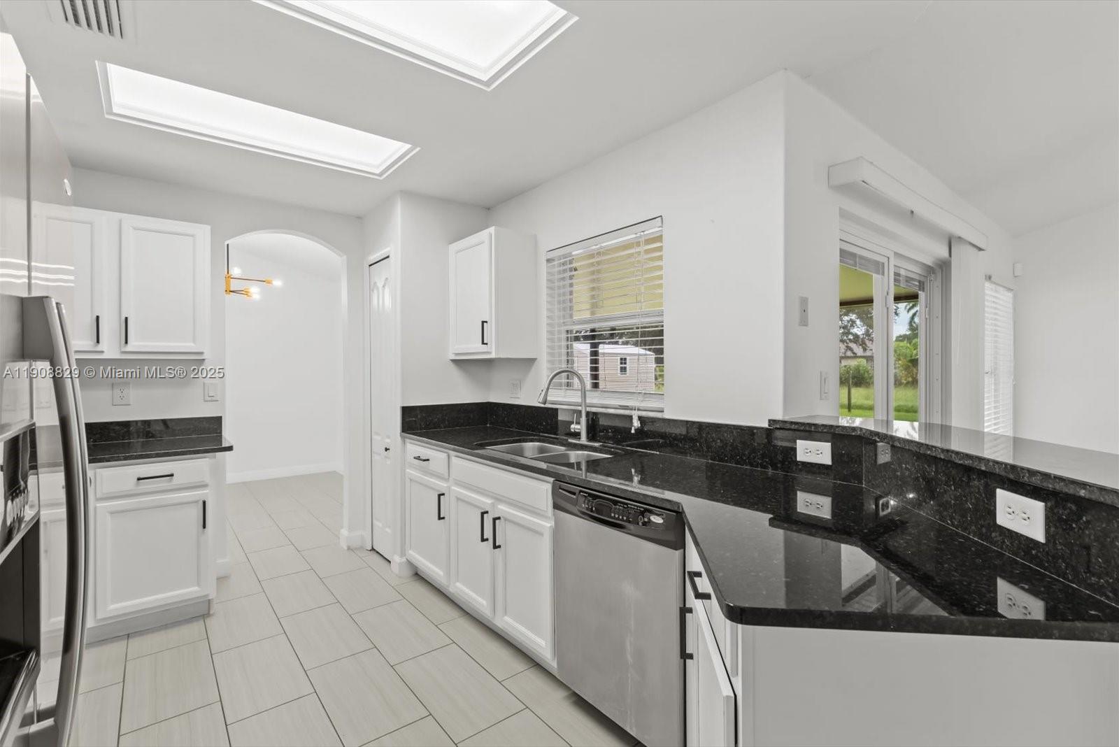 1392 Southwest Sudder Avenue Port St. Lucie, FL 34953 - Photo 11 of 30 a kitchen with a sink stove and cabinets