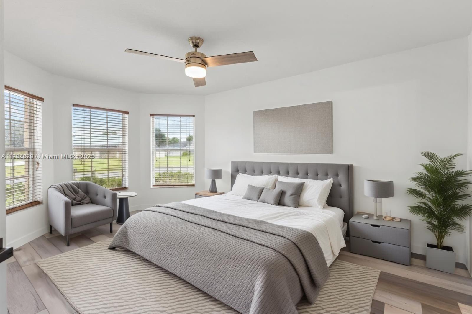 1392 Southwest Sudder Avenue Port St. Lucie, FL 34953 - Photo 12 of 30 a bedroom with a large bed couch and windows