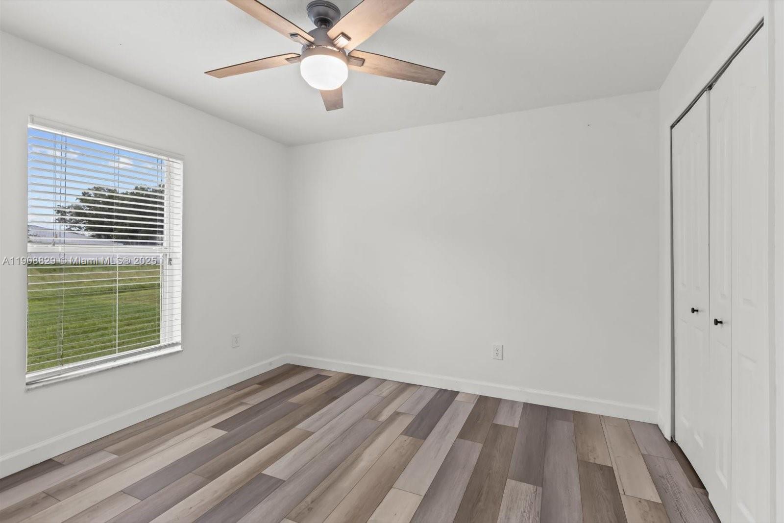 1392 Southwest Sudder Avenue Port St. Lucie, FL 34953 - Photo 22 of 30 a view of an empty room with wooden floor and a window