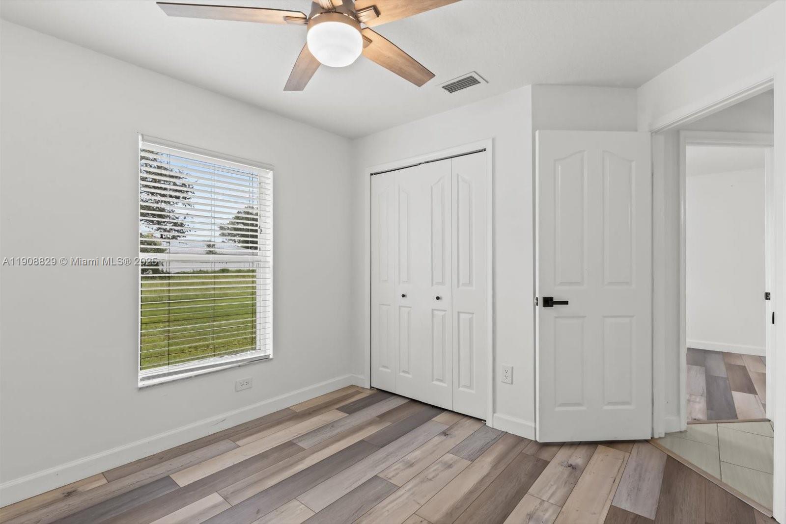 1392 Southwest Sudder Avenue Port St. Lucie, FL 34953 - Photo 25 of 30 a view of an empty room with wooden floor and a window