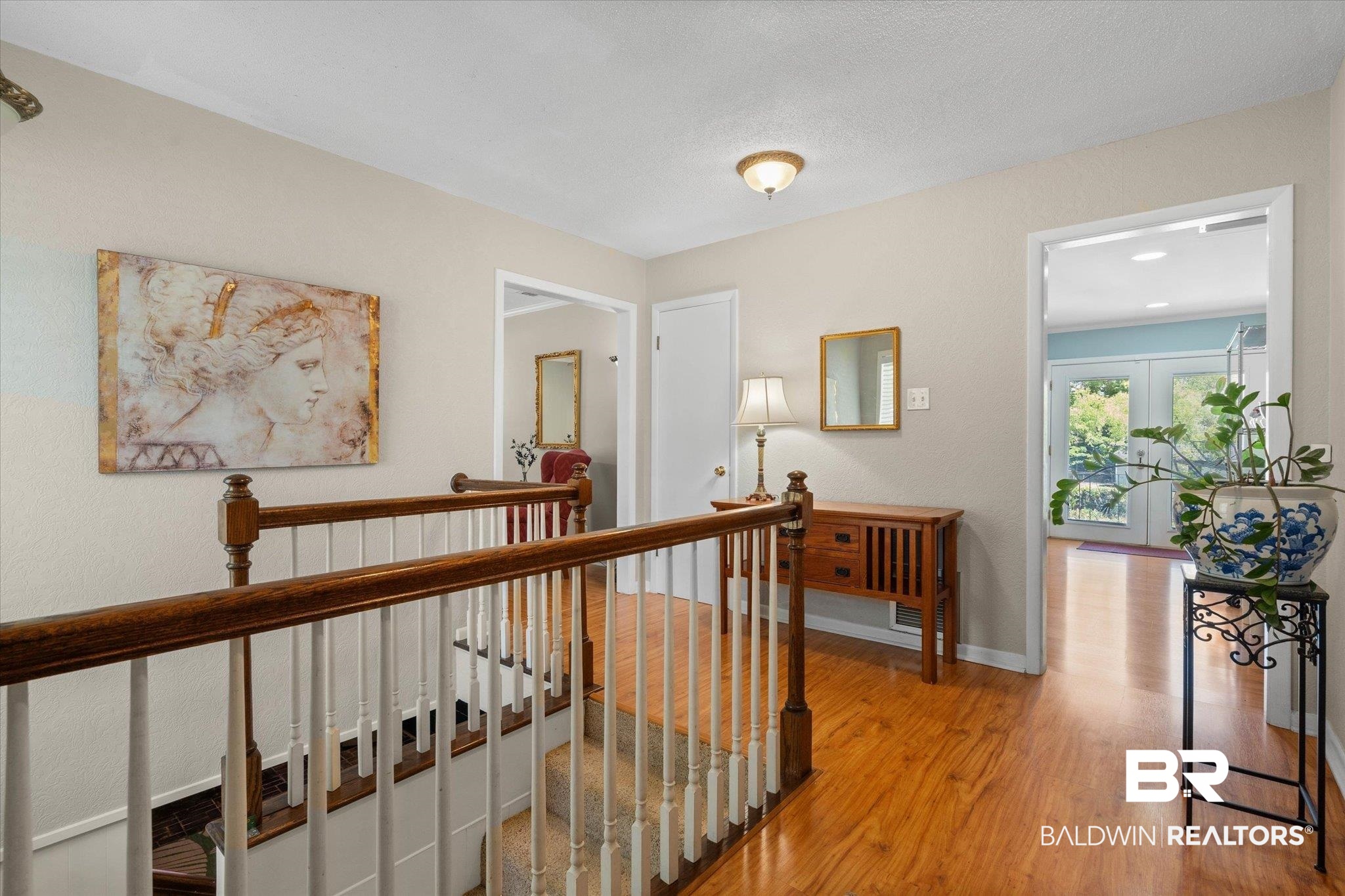706 Sutherland Drive Chickasaw, AL 36611 - Photo 2 of 33 Hallway featuring wood finished floors, baseboards, and an upstairs landing