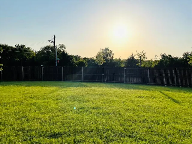 a view of yard with swimming pool and trees in the background