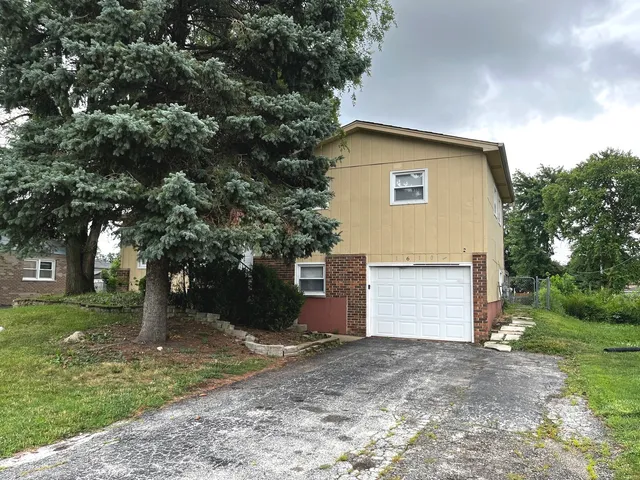 a view of a house with a yard and tree