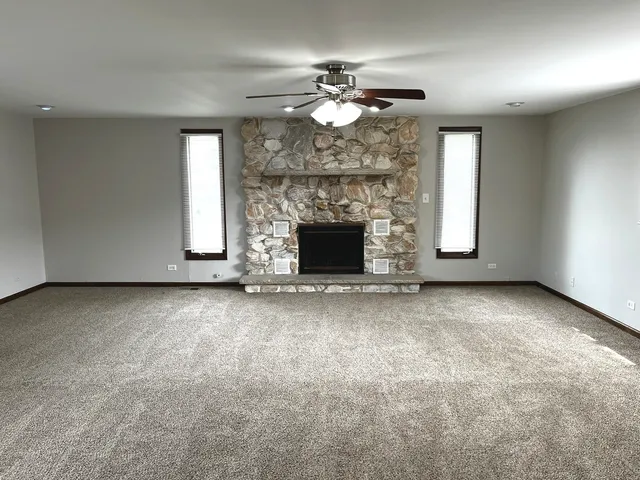 an empty room with a fireplace and chandelier