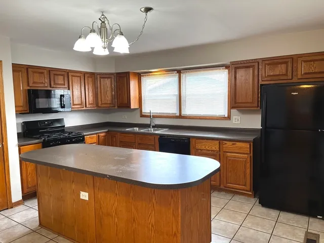 a kitchen with stainless steel appliances granite countertop a sink a refrigerator and a granite counter tops