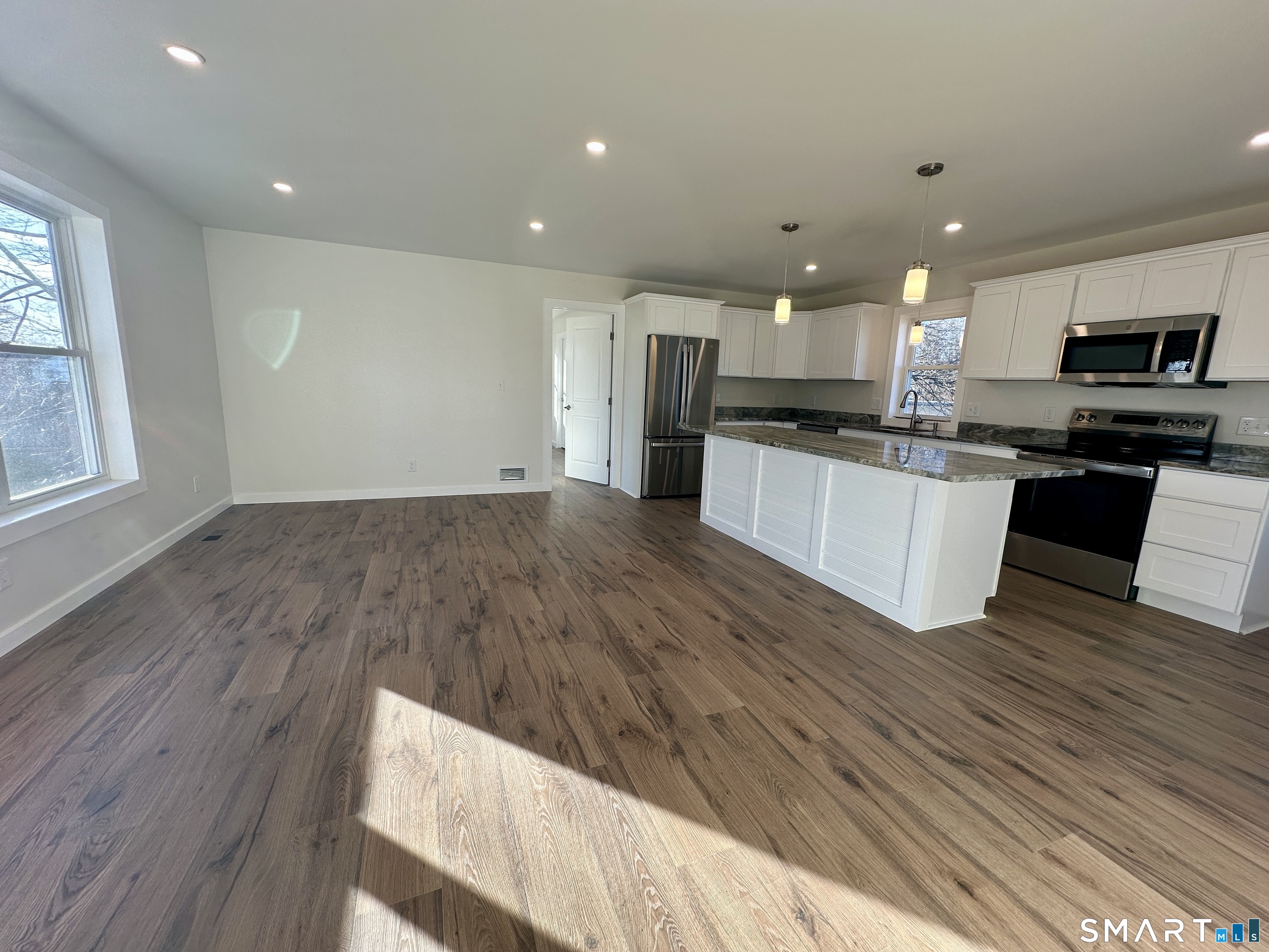48 Cedar Street, Unit D Branford, CT 06405 - Photo 13 of 27 a open kitchen with kitchen island a sink dishwasher stove and oven with wooden floor
