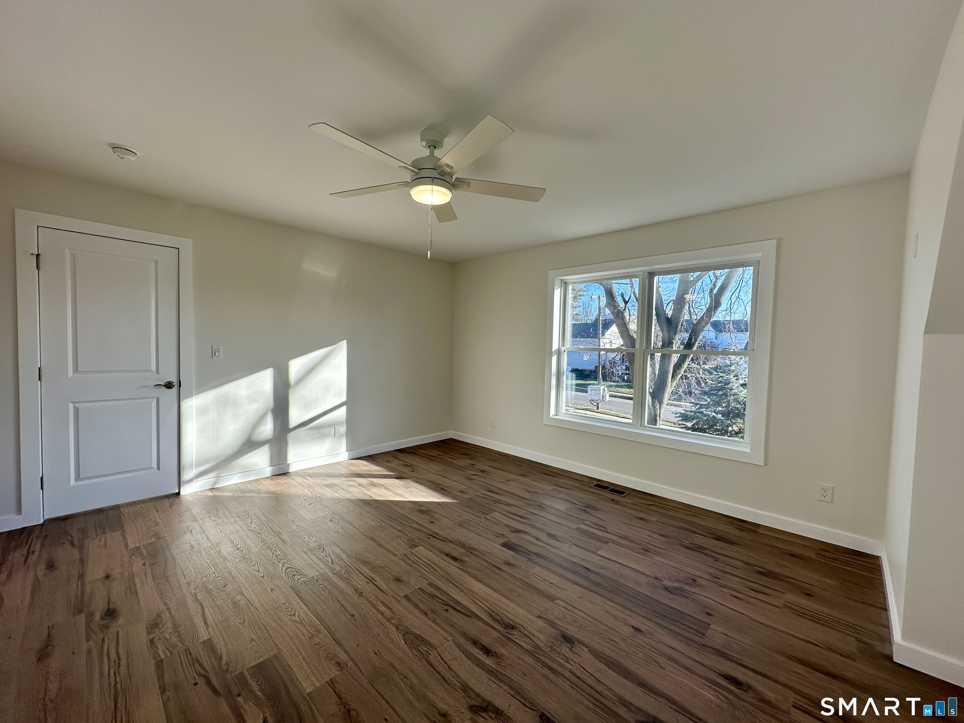 48 Cedar Street, Unit D Branford, CT 06405 - Photo 17 of 27 a view of an empty room with wooden floor and a window