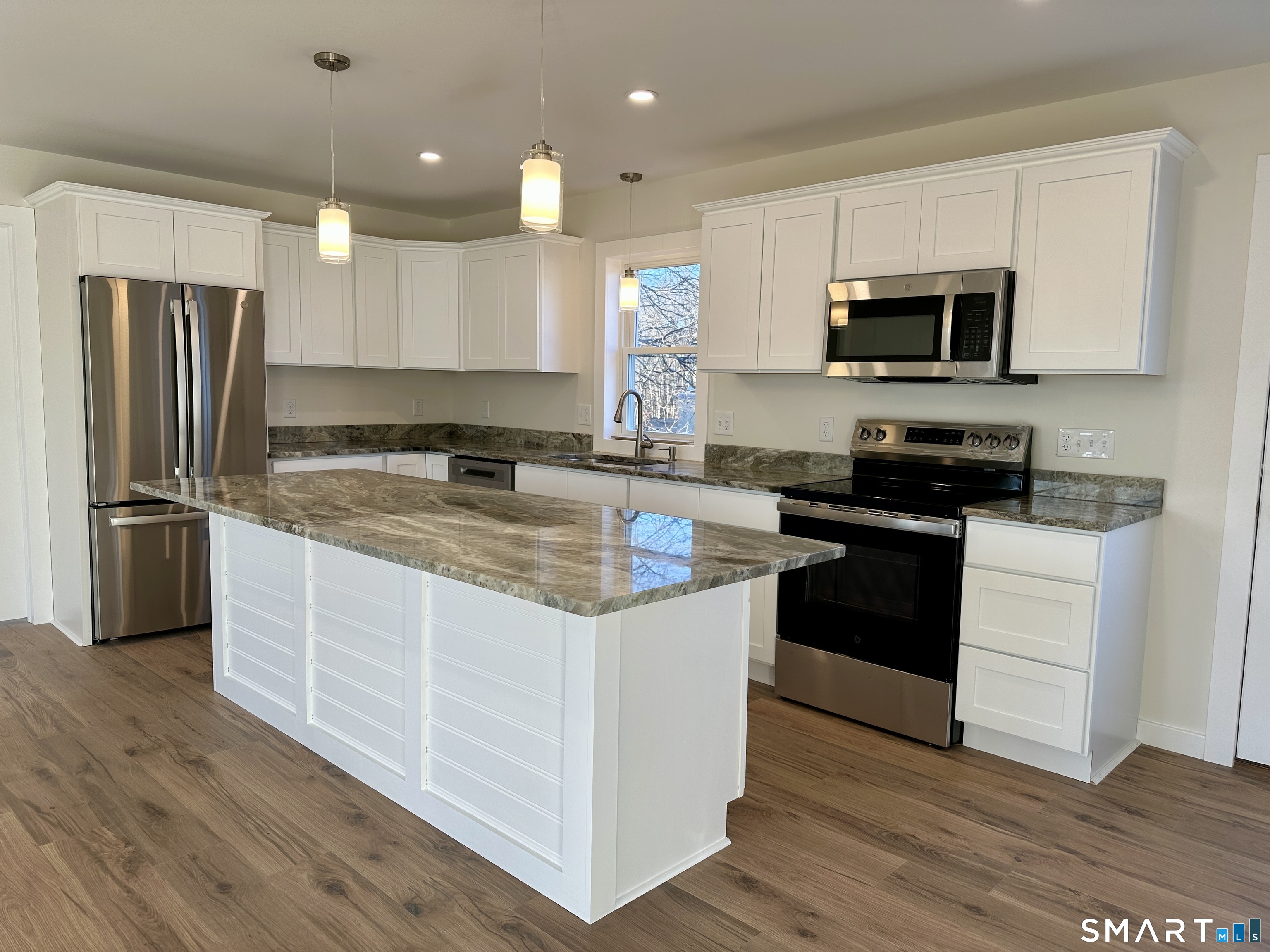 48 Cedar Street, Unit D Branford, CT 06405 - Photo 10 of 27 a kitchen with stainless steel appliances granite countertop a refrigerator a stove a sink a microwave and white cabinets