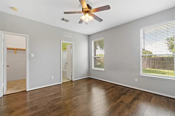 a view of an empty room with window and wooden floor