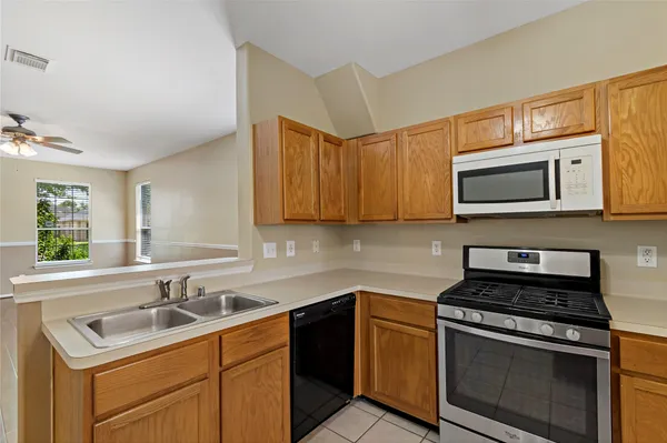 a kitchen with stainless steel appliances granite countertop a sink stove and microwave