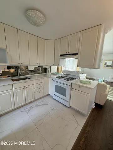 a kitchen with white cabinets appliances and a sink