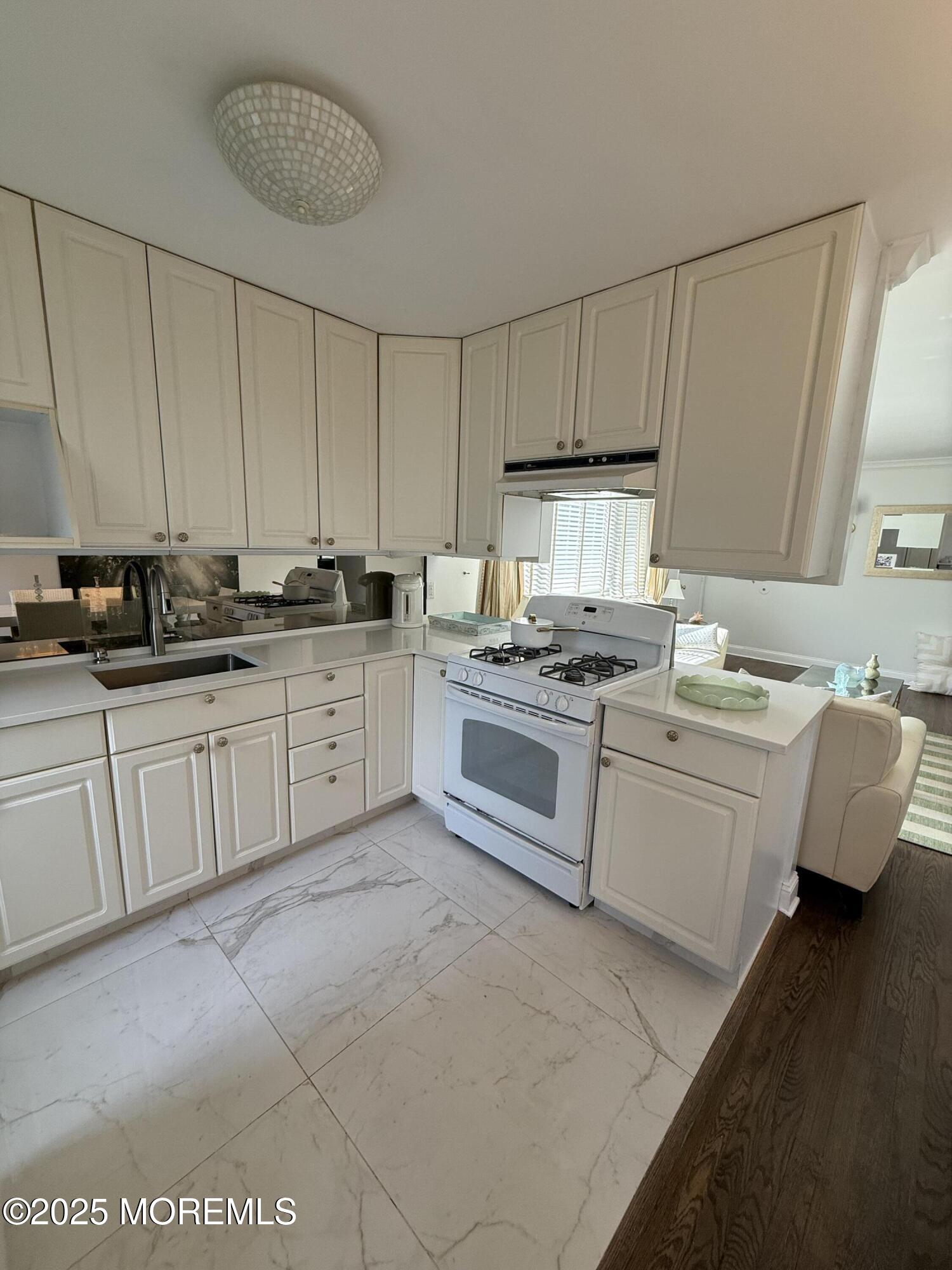 35 Sternberger Avenue, Unit A Long Branch, NJ 07740 - Photo 11 of 18 a kitchen with white cabinets appliances and a sink
