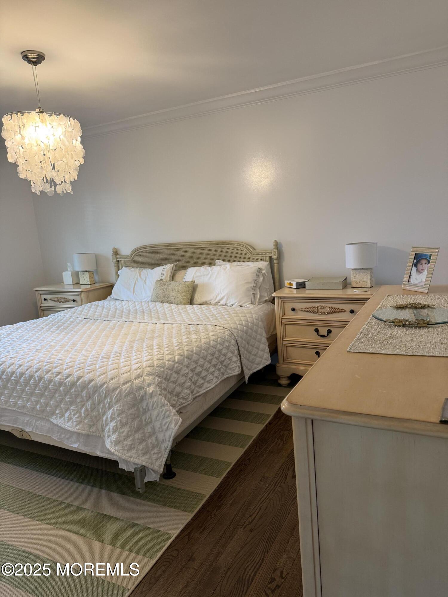 35 Sternberger Avenue, Unit A Long Branch, NJ 07740 - Photo 15 of 18 a bedroom with a bed and a chandelier